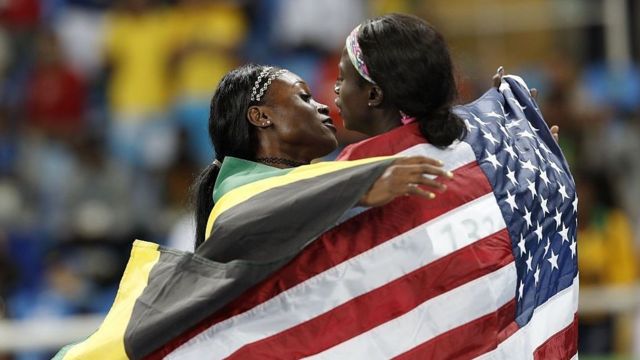 Gold medalist Elaine Thompson, of Jamaica, presents the silver to Tori Bowie, of USA (D), in the women's 100m at the 2016 Rio Olympics