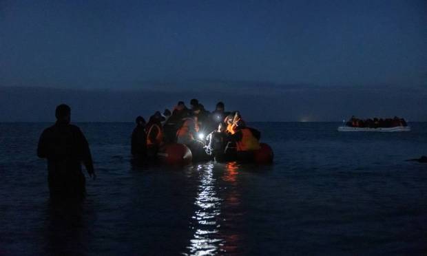Migrants prepare to cross the English Channel to England on a night rubber boat near Wimereau, northern France. Photo: MARC SANYE / AFP