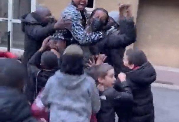 Children celebrate with Nene for a "great goal" at a window in Paris