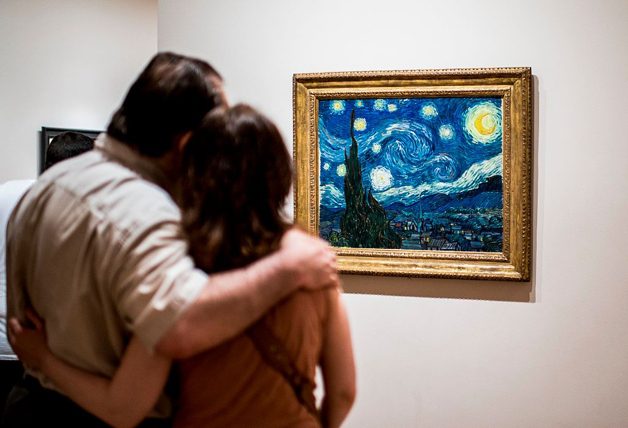 Visitors look at the painting "starry night"by Van Gogh, at the Museum of Modern Art in New York